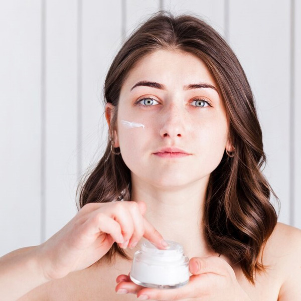 woman applying cream face moisturizing and brightening creams